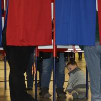Loribeth Reynolds/Collegian - A child waits on the floor, next to a voting booth, for the adult he was there with to finish voting.