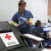 Loribeth Reynolds/Collegian - A Red Cross nurse prepares to collect a unit of blood on a new-model, padded cot now used in the blood drives.