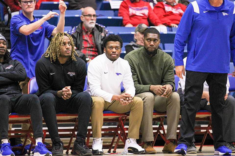 Anthony White (green shirt) watches a Blue Dragon men's basketball game earlier this season at the Sports Arena. Photo by Shelby Spreier.