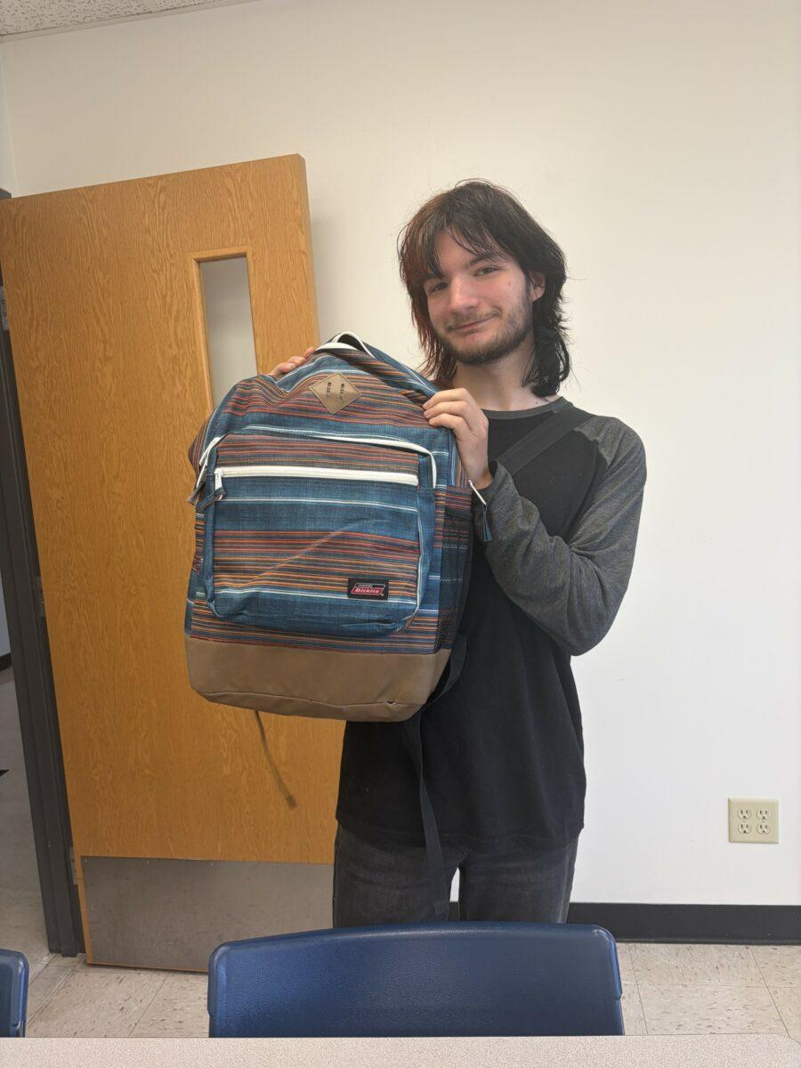 Hutchinson Community College student Marshall Kesinger shows off his backpack after an Intro to Mass Communications class at Building 12. Photo by Kayla Milhon/Collegian.